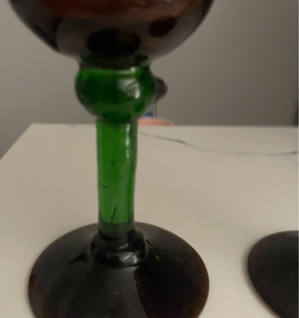Glass with green stem on a white surface